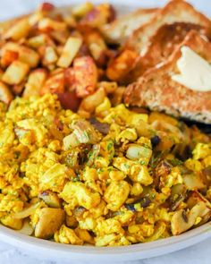 a plate with eggs, potatoes and toast on it