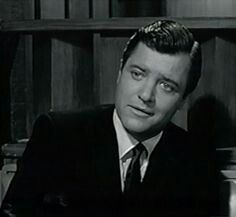 a man in a suit and tie sitting at a desk