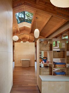 the inside of a house with wood flooring and wooden ceiling lights hanging from the ceiling