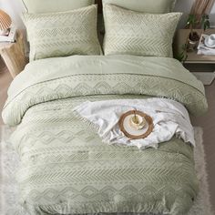 a bed with green comforters and pillows