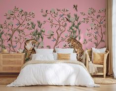 two zebras standing in front of a pink wall with trees and flowers on it