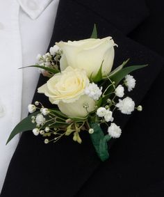 a boutonniere with white roses and baby's breath flowers on it