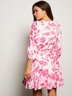 Pink femme florals are calling your name. The Derby Dress takes on this vintage inspired bold pink floral print, making it the perfect pick for a spring soiree. It features a round neck, balloon sleeves, while an attached tie adds some detail at the waist. A flouncy skirt flares out creating a preppy look. Wear it on a date or to a bridal shower with coordinating strappy heels for the ultimate look.- Keyhole- Elastic waist- Tie belt- Godet pleats- Color: White PinkSize + Fit- Model is 5'10" and Pink Floral Printed Dress For Spring, Pink Printed Floral Dress For Spring, Feminine Balloon Sleeve Spring Dresses, Pink Printed Floral Dress For Brunch, Pink Balloon Sleeve Dress For Spring, Pink Balloon Sleeve Dress For Garden Party, Spring Feminine Floral Dress With Puff Sleeves, Feminine Pink Floral Printed Dress, Feminine Pink Printed Floral Dress