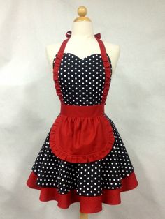 a dress on a mannequin with black and white polka dots, red trim