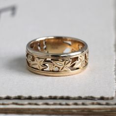 "A beautifully detailed vintage band crafted in solid 18k yellow gold showcasing the centuries-old language of flowers with it's articulated ivy motif. The ivy leaf was used to represent the ideals of fidelity, marriage, friendship and affection; it's meaning is underlined by the eternity style of the ring, unbroken and endless. Originally meant as a wedding ring, it would be perfect worn in a stack with other interesting bands or on its own as a solo statement. Measuring approximately 6.88 mm w Heirloom Gold Flower Ring, Vintage Yellow Gold Rings With Decorative Band, Classic 14k Stamped Yellow Gold Flower Ring, Heirloom Yellow Gold Flower Ring With Intricate Design, Heirloom Yellow Gold Flower Ring Hallmarked, Hallmarked Heirloom Yellow Gold Flower Ring, Heirloom 14k Gold Engraved Flower Ring, Heirloom Engraved 14k Gold Flower Ring, Anniversary Yellow Gold Engraved Flower Ring