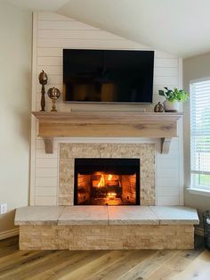 a living room with a fireplace and television above it