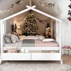 a white bed sitting under a christmas tree