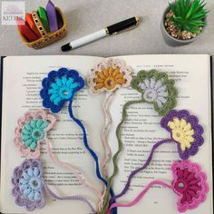 an open book with crocheted flowers on it