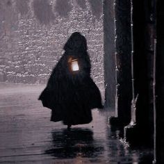 a person walking in the rain with an umbrella and a light on their head,