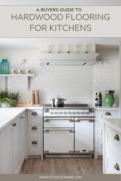 a kitchen with white cabinets and an oven in the center, surrounded by green vases