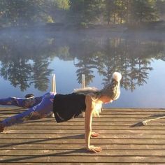 a woman is doing yoga on a dock