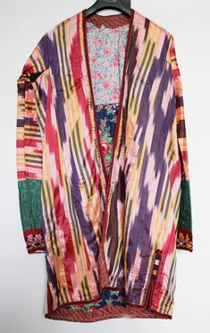 Vintage original kaftan from Uzbek people, Central Asia made with the Ikat technique. Beautiful embroidery on the sleeves and the collar. The ceremonial coat is worn open and has therefore no buttons, hooks, nor belt. The inside is lined with colored fabric with a floral print. Size: comparable to European size M-L shoulder width: 45 cm chest: 55 cm sleeve length: 64 cm cuff width: 14 cm total length: 104 cm CA174 If sold outside the EU, the buyer is responsible for paying import duties. To go b Festive Long Sleeve Kaftan With Woven Motifs, Multicolor Long Sleeve Kaftan With Woven Motifs, Long Sleeve Multicolor Kaftan With Woven Motifs, Transitional Embroidered Multicolor Kaftan, Traditional Multicolor Transitional Season Kaftan, Bohemian Kaftan With Traditional Patterns For Ceremonial Events, Bohemian Kaftan For Traditional Ceremonies, Festive Multicolor Kaftan With Woven Motifs, Festive Multicolor Woven Motif Kaftan