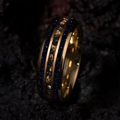 a gold ring with blue and yellow glitters