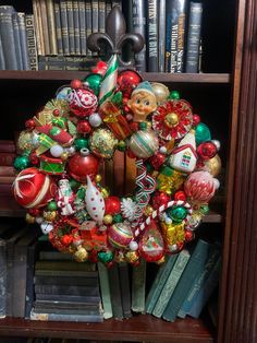 a christmas wreath sitting on top of a book shelf