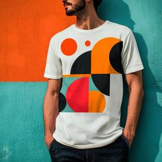 a man standing in front of a wall wearing a t - shirt with an abstract design