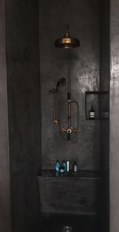 a bathroom with a toilet, sink and shower head in the wall next to it