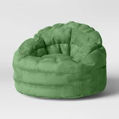 a green bean bag chair sitting on top of a white floor