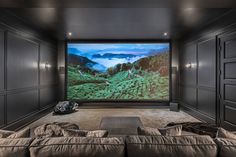 a large screen in the middle of a room with couches and pillows on it