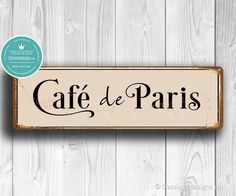 a wooden sign that says cafe de paris on the side of a white wood wall