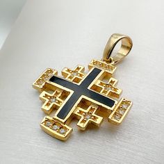 Immerse yourself in divine elegance with our 14k Gold Jerusalem Cross Pendant, adorned with Black Enamel and Zircons, a harmonious blend of spiritual significance and exquisite craftsmanship. 🌟 Meaning of the Jerusalem Cross: The Jerusalem Cross, with its distinctive design featuring four smaller crosses surrounding a central one, holds deep religious symbolism. Each arm represents the foundational Christian virtues of faith, hope, love, and the central message of the Gospel. ⛪️ Pointing to the Black Symbolic Cross Pendant Jewelry, Traditional Gold Jewelry With Black Enamel, Symbolic Black Cross Pendant Jewelry, Black Symbolic Jewelry For Anniversary, Symbolic Black Gemstone Jewelry, Black Symbolic Anniversary Jewelry, Symbolic Black Jewelry For Anniversary, Traditional Black Jewelry For Anniversary, Symbolic Black 14k Gold Jewelry