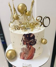 a white and gold birthday cake with an image of a woman on it