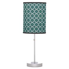 a lamp with a green and yellow flower design on the shade, it is lit up