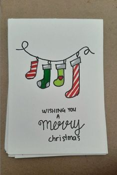 a christmas card with stockings hanging from a line and the words wishing you merry christmas