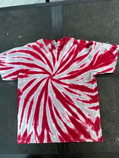 a red and white tie - dyed t - shirt sitting on top of a table