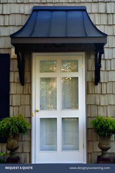 the front door to a house with two potted plants