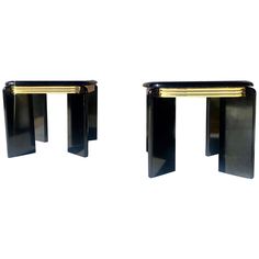 a pair of black and gold side tables on white backgroung with one end in the middle