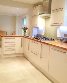 a kitchen filled with lots of white cabinets and counter top space next to a dining room table