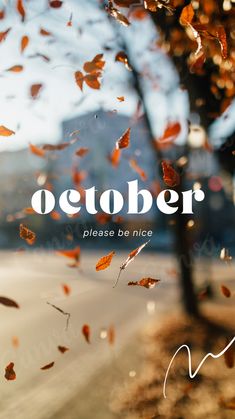 the words october are written in white on a blurry background with leaves falling from a tree