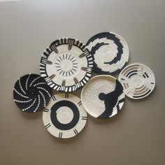 four black and white plates with designs on the top one is shaped like a spiral