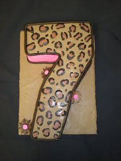 the number seven cake is made to look like a leopard print with pink accents on it