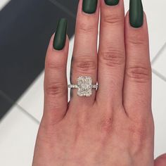 a woman's hand with green nail polish and a ring on her left hand