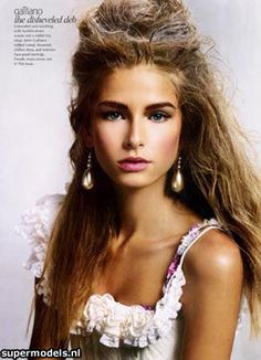 a beautiful young woman with long hair in a white dress posing for a magazine cover