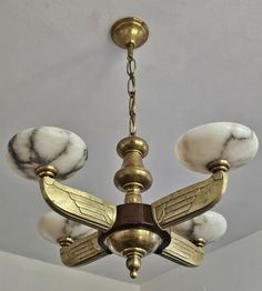 a chandelier hanging from the ceiling with marbled shades on it's wings