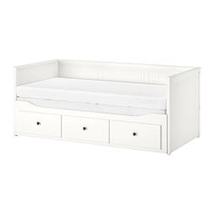 a white bed with drawers underneath it and a mattress on the bottom shelf in front of it