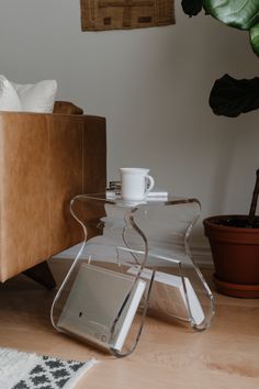 a glass coffee table sitting on top of a hard wood floor next to a couch