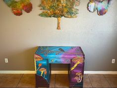 an artistically painted desk sits against a wall