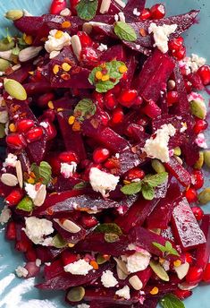 beet salad with goat cheese and pomegranates on a blue plate