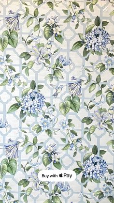 a blue and white flowered wallpaper with green leaves on the bottom half of it