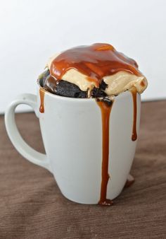 a cup filled with ice cream and caramel drizzled on top of it