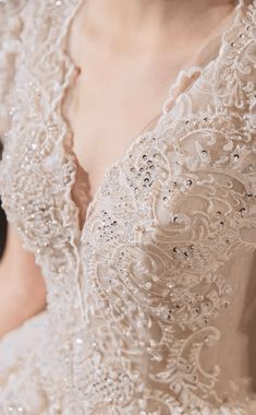 the back of a woman's wedding dress with beading and sequins