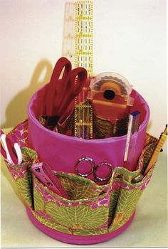 a pink container with scissors, pens and other items in it