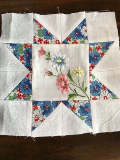 a quilted table topper with flowers on it