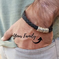 a man wearing a bracelet with the words your family written on it