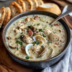 a bowl of clam chowee with bread on the side