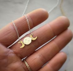 Capture the beauty and mystery of the night sky with our celestial-inspired moon phase necklace The pendant showcases a harmonious blend of metals with a solid .925 silver chain anchored to a centerpiece crafted from two polished brass crescent moons framing a handcrafted silver full moon at its heart. The center of the pendant holds a silver moon that's been carefully crafted by melting and hammering the metal by hand. The resulting shape and texture are wonderfully imperfect, creating a unique Celestial Crescent Moon Phase Necklace, Adjustable Moon-shaped Sterling Silver Jewelry, Adjustable Sterling Silver Moon-shaped Jewelry, Adjustable Sterling Silver Moon Jewelry, Gold Half Moon Shaped Metal Jewelry, Adjustable Moon Phase Necklace, Adjustable Moon Phase Jewelry, Spiritual Sterling Silver Moon Phase Necklace, Brass Moon Charm Jewelry