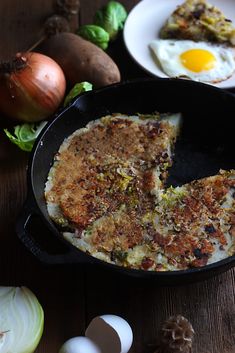 an egg is in a skillet next to some vegetables and other food on the table